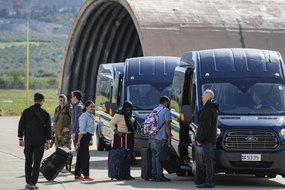 Passengers from Sudan get on busses at Tanagra air base, north of Athens, Wednesday, April 26, 2023. Sixteen Greeks and one Cypriot arrived in Greece after being evacuated from Sudan. (AP Photo/Thanassis Stavrakis)