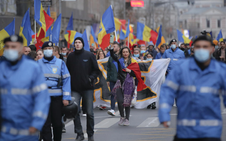 People march during a protest against the COVID-19 pandemic restrictions in Bucharest, Romania, Saturday, April 3, 2021. Thousands of anti-restriction protesters took to the streets in several cities across Romania. (AP Photo/Vadim Ghirda)