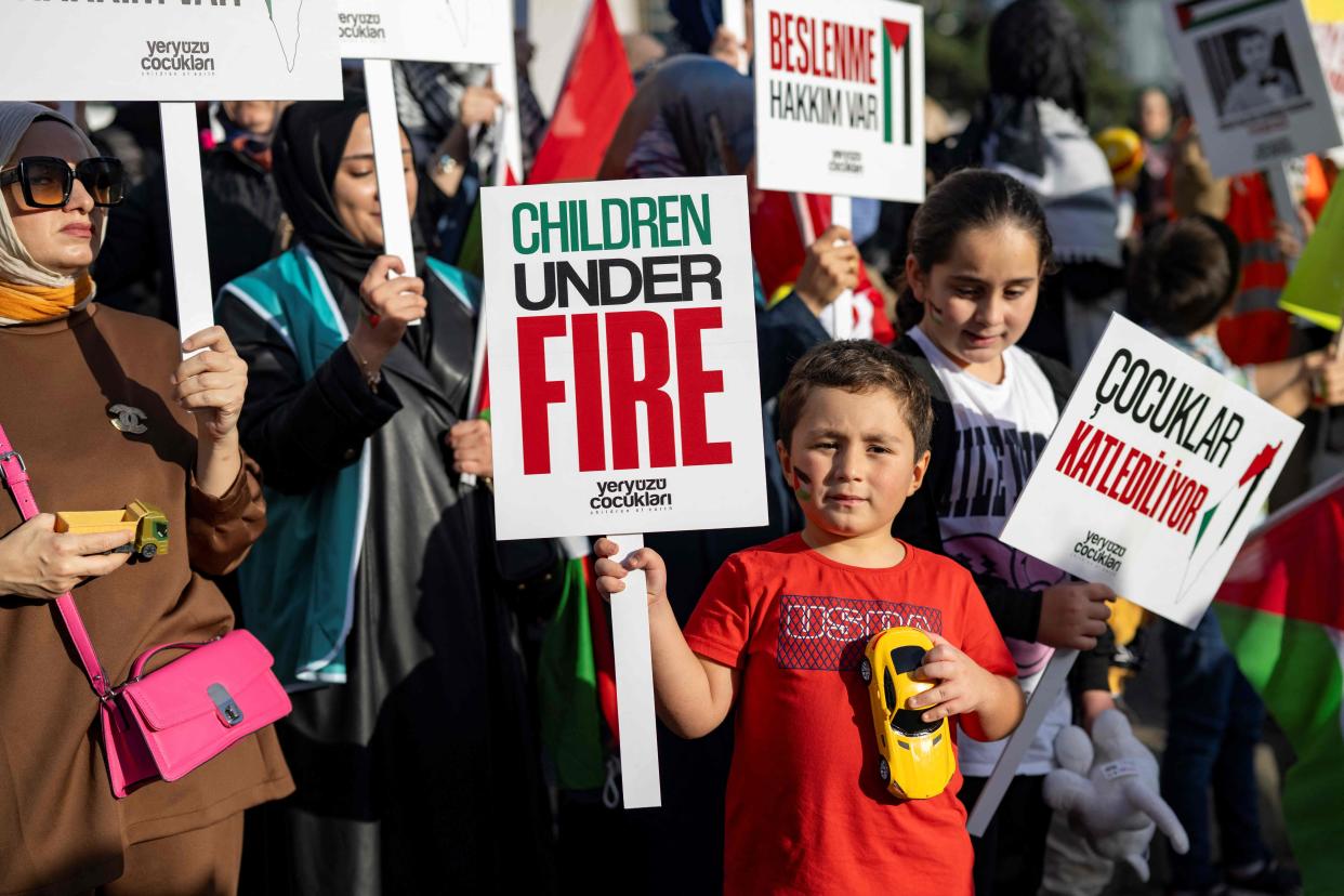 Protestors hold placards during a demonstration in support of Palestinians near the Israeli consulate (AFP via Getty Images)