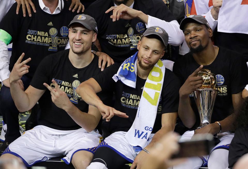Klay Thompson (left), Stephen Curry (center) and Finals MVP Kevin Durant celebrate their 2017 NBA championship.