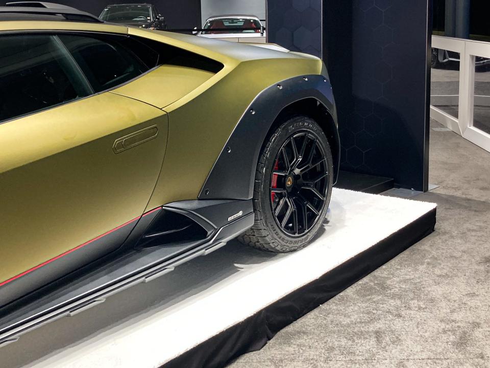 The rear wheel of the Lamborghini Huracan Sterrato, including a knobby off-road tire and plastic cladding.