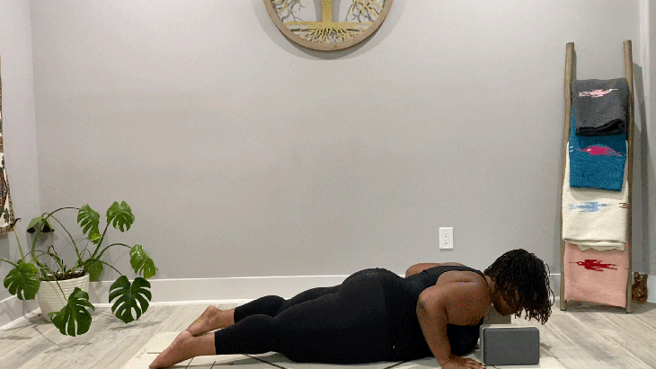 Woman practicing a low push-up on a yoga mat during a slow flow practice