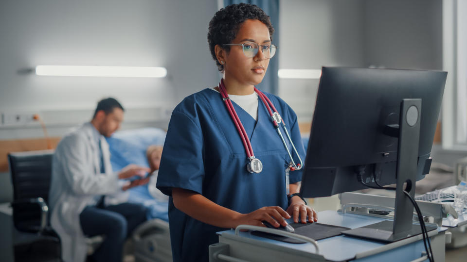 a medical worker looking at a computer