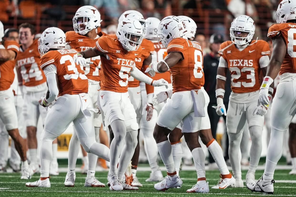Texas defensive back Terrance Brooks, right, is congratulated by fellow defensive back Malik Muhammad during Friday night's win. Both ended the night with interceptions.