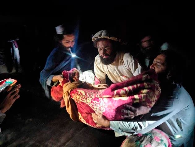 Afghans evacuate the injured from damaged homes. (Photo: Bakhtar News Agency via Associated Press)