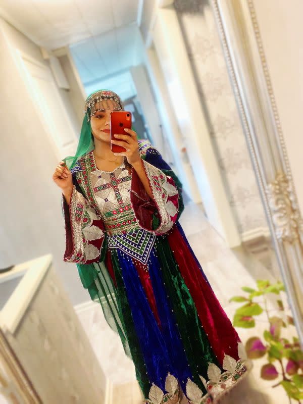 A woman poses in traditional Afghan attire, in Stockholm