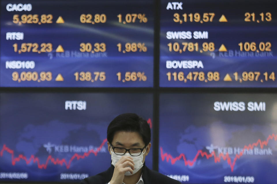 A currency trader adjusts his mask at the foreign exchange dealing room of the KEB Hana Bank headquarters in Seoul, South Korea, Wednesday, Jan. 29, 2020. Shares are mostly higher in Asia after a rebound on Wall Street that reversed most losses from a sell-off the day before. (AP Photo/Ahn Young-joon)