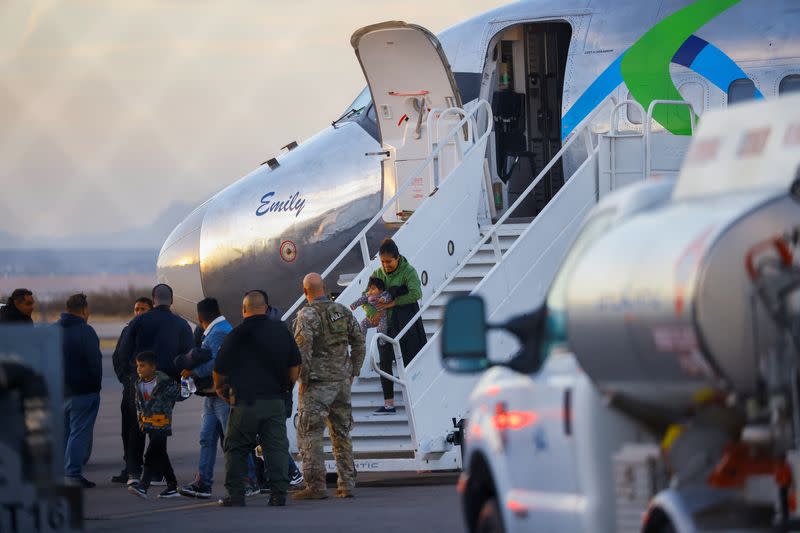 Migrants, transferred from Plattsburgh, New York to El Paso, Texas, disembark from a plane at the airport, in El Paso