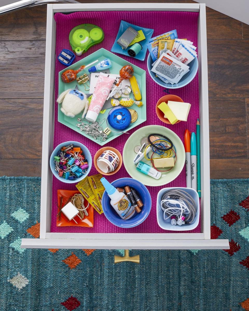 <p>Give all those adorable little plates, cups, and bowls that you (admit it) barely use a second life as micro-organizers. Arrange them so you can squeeze in as many as possible — the more landing spots, the easier your it will be to find what you need. Keep the dishes from sliding with a nonslip drawer liner made out of an old yoga mat.</p><p><em><a href="http://www.iheartorganizing.com/2014/02/uheart-organizing-junk-drawers-that.html" rel="nofollow noopener" target="_blank" data-ylk="slk:Find more junk drawer inspo at I Heart Organizing »;elm:context_link;itc:0;sec:content-canvas" class="link ">Find more junk drawer inspo at I Heart Organizing »</a></em></p>