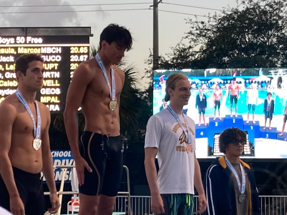 Jupiter senior Leif Bouwman (second from right) stands on the platform to receive his medal after taking third in the 50-meter free.