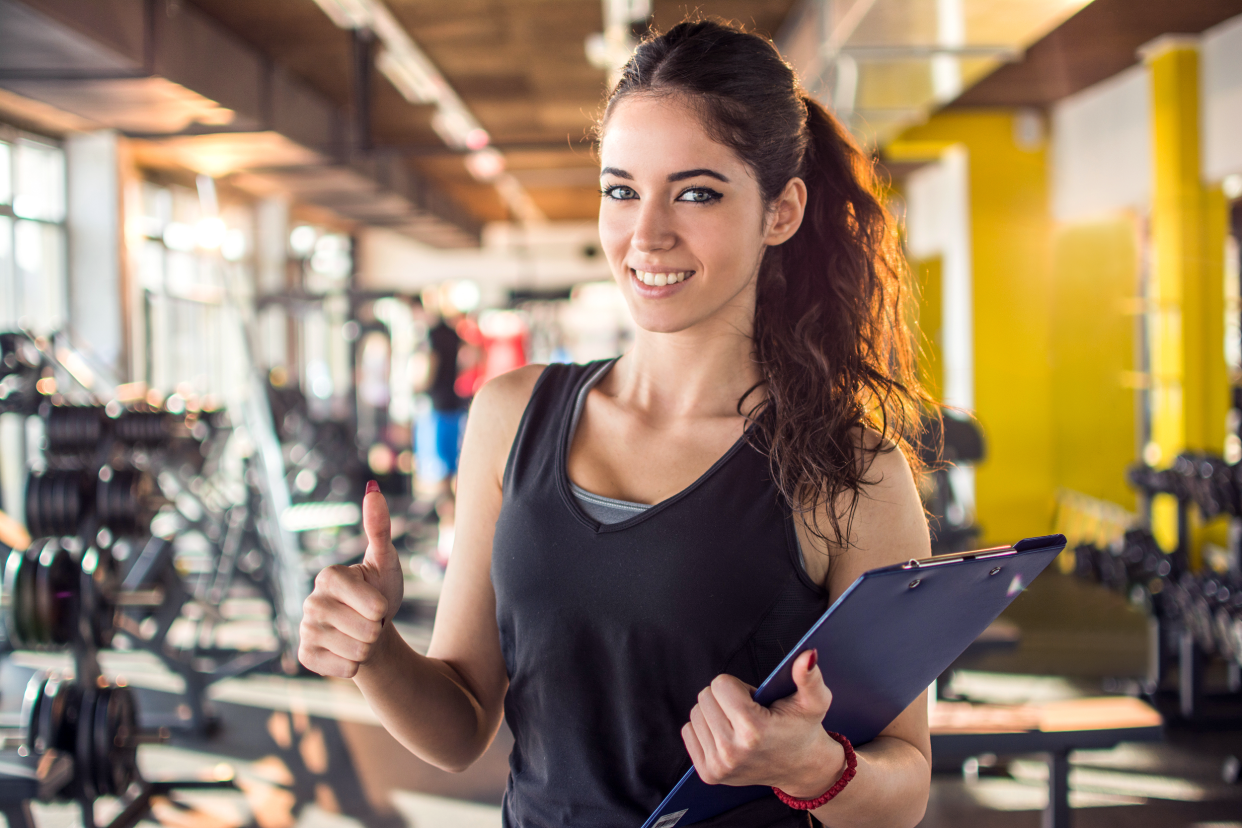 Female personal trainer giving a thumbs up