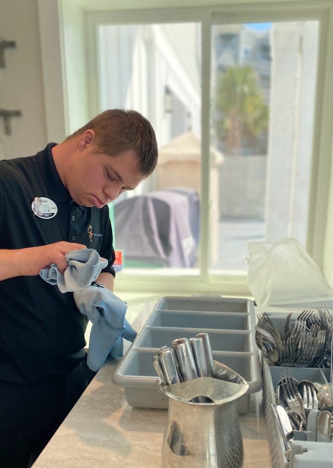 Intern Dylan Nicholas polishes silverware at a St. Johns County retirement community as part of a school district career training program for young adult students who have developmental differences.
