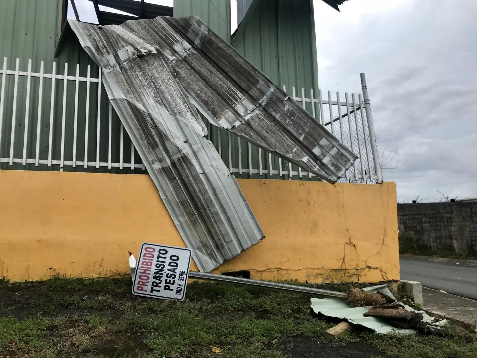 <p>A downed “no trespassing” sign lays on the grass in front of a building damaged by Hurricane Maria in Bayamon, Puerto Rico. (Photo: Caitlin Dickson/Yahoo News) </p>