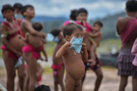 En la imagen, un niño indígena del pueblo yanomami intenta colocarse una mascarilla en la aldea de Surucucu, en el estado brasileño de Roraima. (Foto: Nelson Almeida / AFP / Getty Images).