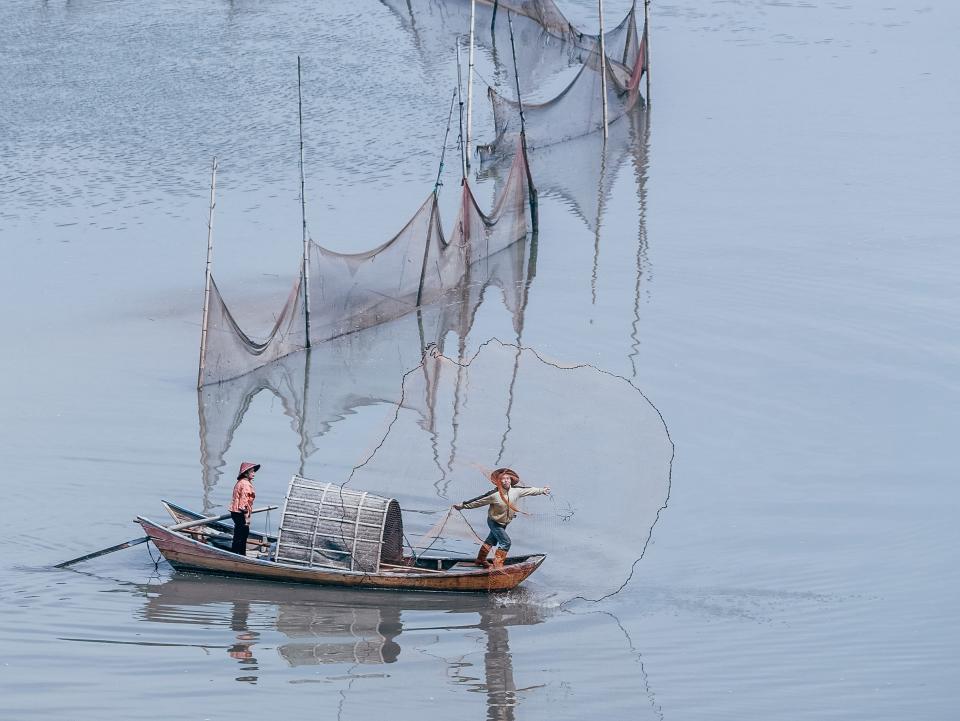 Fishermen on a boat in Xiapu cast their nets.