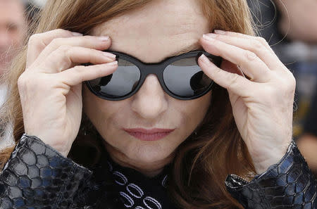 Cast member Isabelle Huppert removes her sunglasses as she poses during a photocall for the film "Louder Than Bomb" (Plus fort que les bombes) in competition at the 68th Cannes Film Festival in Cannes, southern France, May 18, 2015. REUTERS/Regis Duvignau