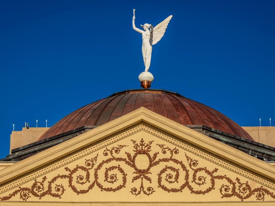 Arizona State Capitol Building at sunrise, features Winged Victory statue and was modeled after Greek statue Nike of Samothrace.