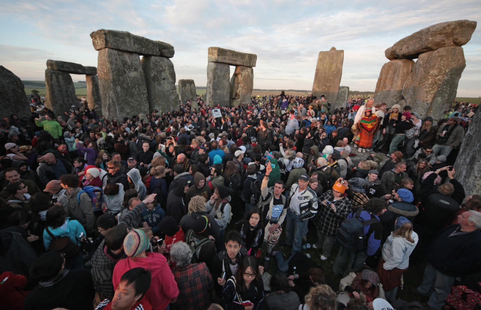 AMESBURY, ENGLAND - JUNE 21:  Revelers watch as the midsummer sun rises just after dawn over the megalithic monument of Stonehenge on June 21, 2010 on Salisbury Plain, England.  (Photo by Matt Cardy/Getty Images)