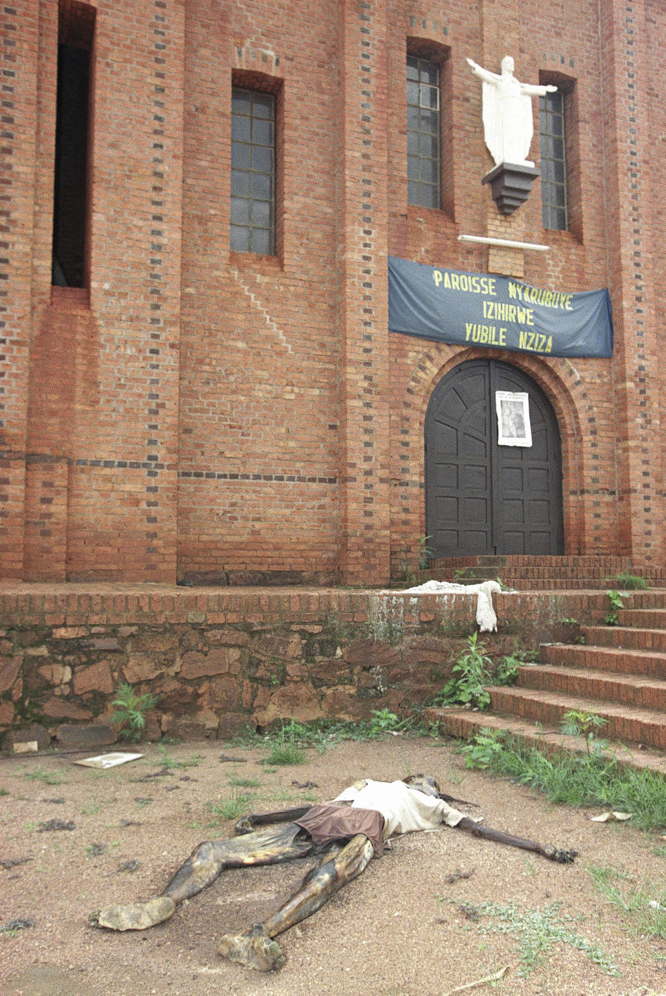 ARCHIVO - Un hombre yace muerto en la entrada de la iglesia católica romana de Nyarubuye en Njarubuje, Rwanda, al este de Kigali, el 31 de mayo de 1994. Extremistas hutus asesinaron a cerca de 800.000 tutsi en masacres que se extendieron por más de 100 días. (AP Foto/Jean-Marc Bouju, Archivo)