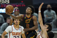 Cleveland Cavaliers' Collin Sexton, left, drives to the basket against Phoenix Suns' Dario Saric in the second half of an NBA basketball game, Tuesday, May 4, 2021, in Cleveland. (AP Photo/Tony Dejak)