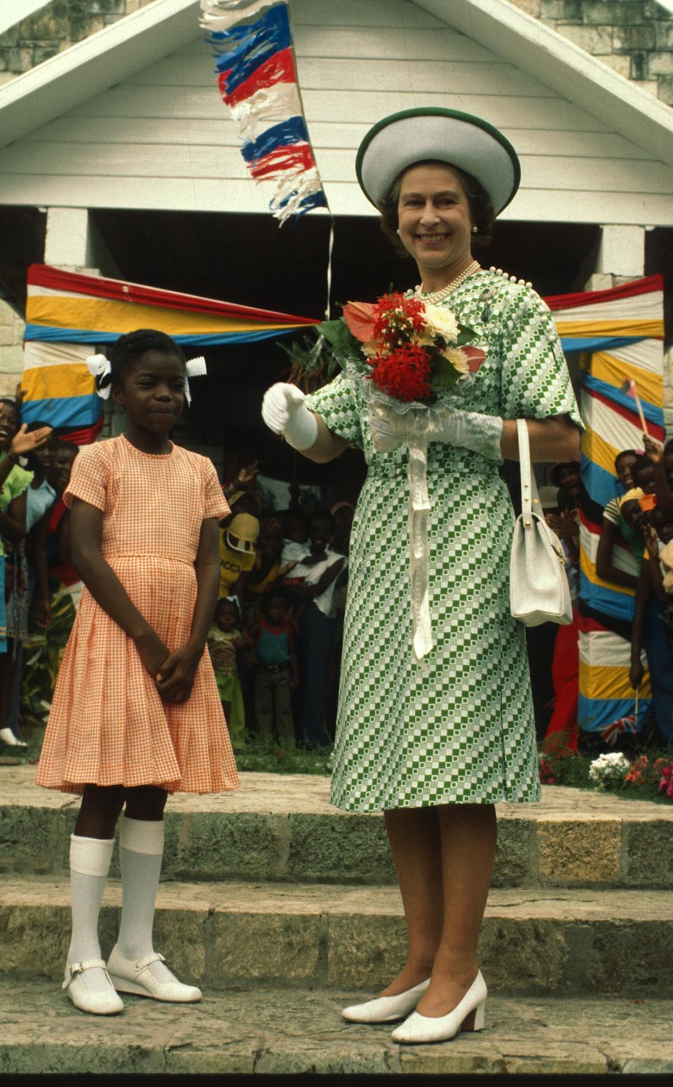 BARBADOS - NOVEMBER 01: Queen Elizabeth ll smiles with a young girl in Barbados on November 01, 1977 in Barbados. (Photo by Anwar Hussein/Getty Images)