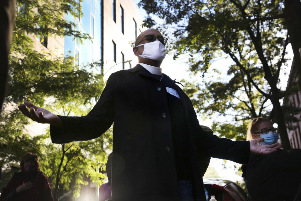 Pastor Derrick McQueen of St. James Presbyterian Church in Harlem, lifts his hands and closes his eyes in prayer during an interfaith gathering outside of the Judson Memorial Church near Washington Square Park in New York, Wednesday, Nov. 4, 2020. Muslims, Jews, Christians and Buddhists came together to show solidarity among faith communities as the country awaits the final result of the U.S. presidential election. (AP Photo/Jessie Wardarski)