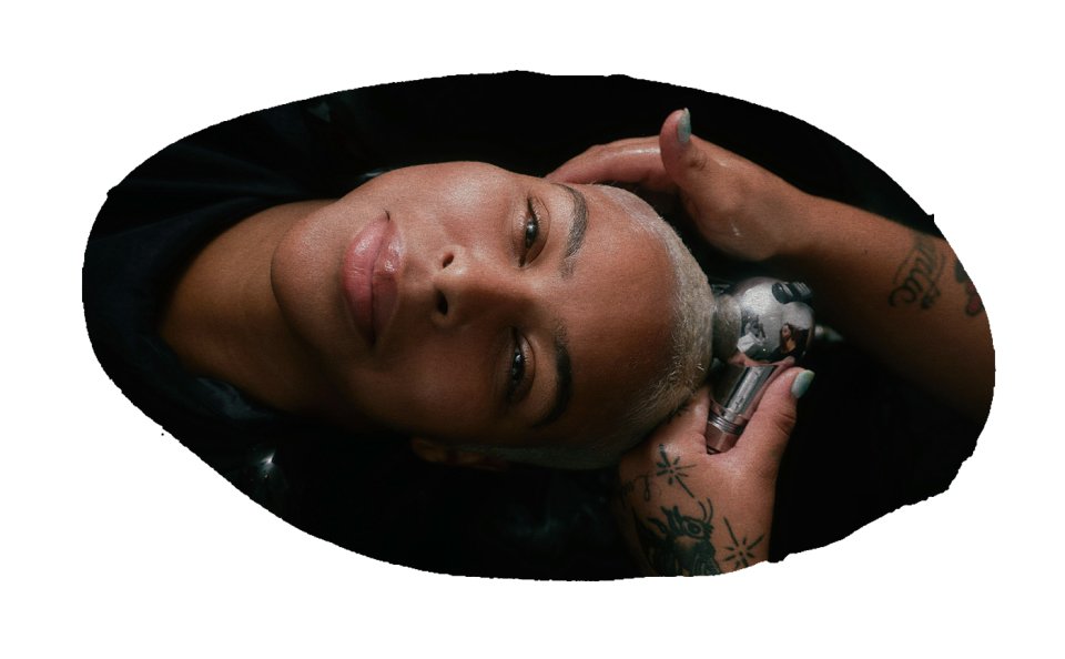 horizontal oval image of Darian Symoné Harvin getting her hair rinsed in a salon sink as she looks up at the camera