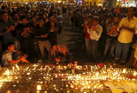 Migrants attend a candle light ceremony at a Budapest railway station in memory of 71 refugees who died in a truck found in Austria, in Budapest, Hungary August 28, 2015. REUTERS/Laszlo Balogh