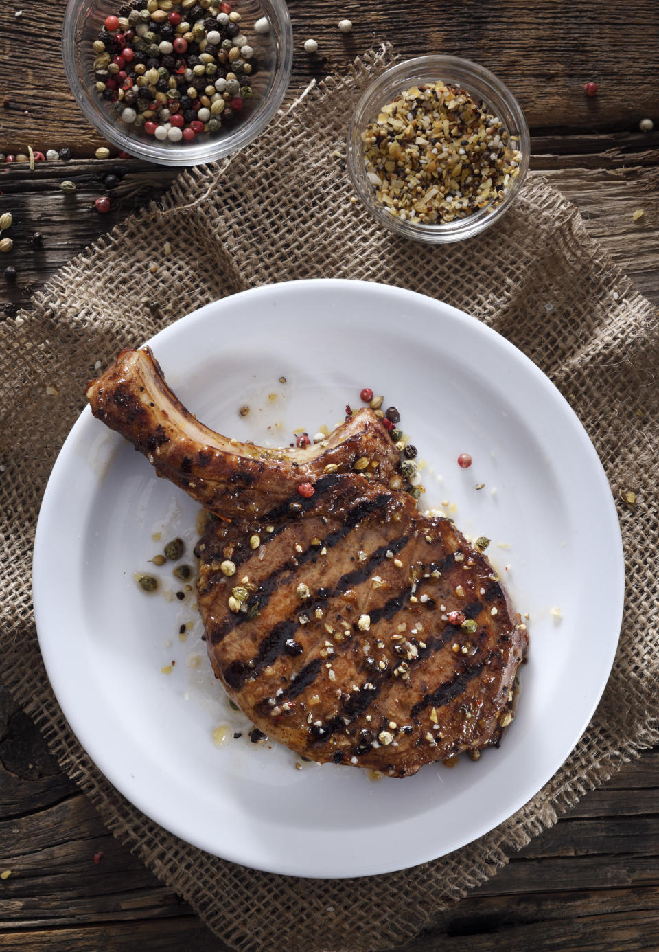 Juicy grilled pork chop with spices on a white plate