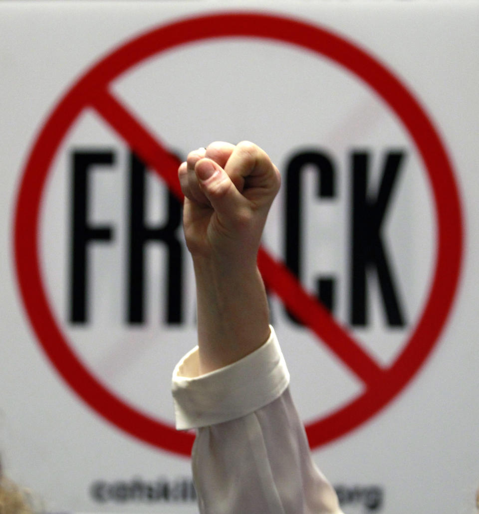 FILE - In this Jan. 23, 2012 file photo, Gillie Waddington of Enfield, N.Y., raises a fist during a rally against hydraulic fracturing of natural gas wells at the Legislative Office Building in Albany, N.Y. In the latest salvo in local battles over gas drilling, a company says it's shutting down wells and stopping free gas to landowners in a western New York town that passed a moratorium on drilling. The town of Avon, 20 miles southwest of Rochester, passed a one-year moratorium on gas drilling and hydraulic fracturing on June 28. Dozens of other towns have enacted similar moratoriums or bans in anticipation of the state completing an environmental review and issuing permits in coming months. (AP Photo/Mike Groll, File)