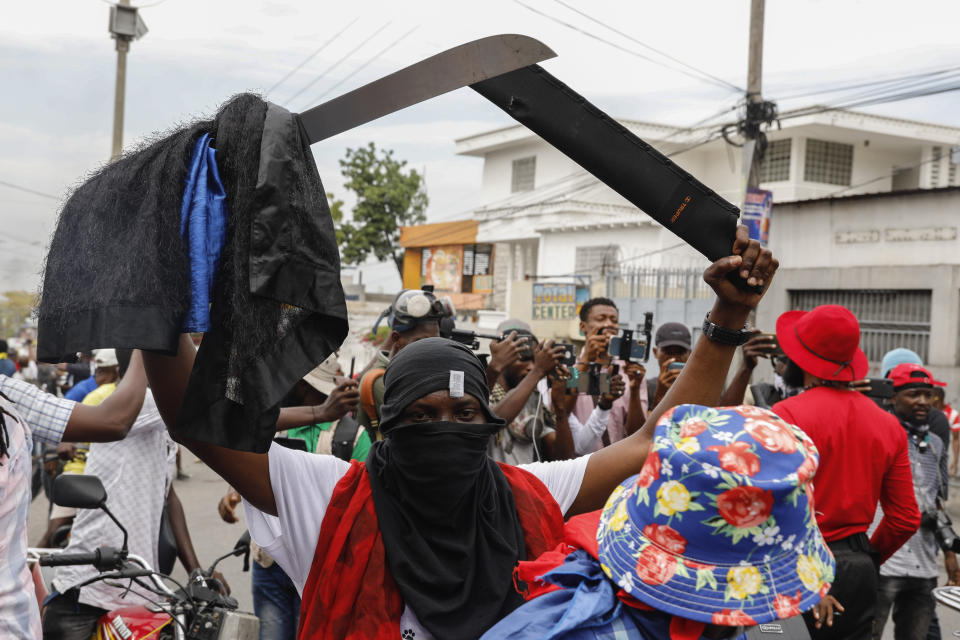 A masked protester wields a machete during a protest against Haitian Prime Minister Ariel Henry in Port-au-Prince, Haiti, Monday, Feb. 5, 2024. Banks, schools and government agencies closed in Haiti’s northern and southern regions on Monday while protesters blocked main routes with blazing tires and paralyzed public transportation, according to local media reports. (AP Photo/Odelyn Joseph)