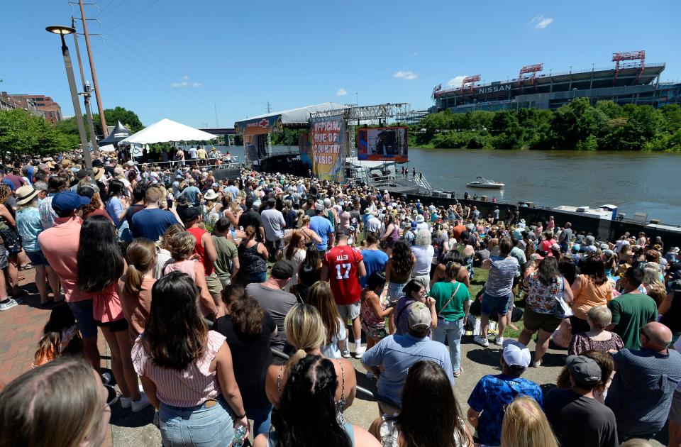 People listen to artists perform at the Riverfront Front Stage during the CMA Fest on Thursday, June 9, 2022, in Nashville, Tenn. 