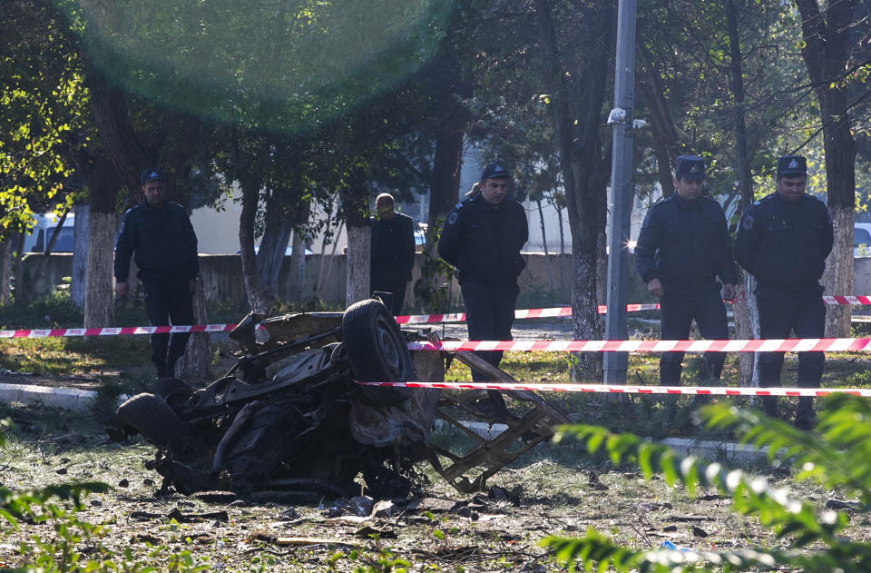 Members of Azerbaijan's security forces, inspect the damage following an overnight missile attack by Armenian forces, in the city of Ganja, Azerbaijan's second-largest city, Thursday, Oct. 8, 2020. The fighting between Armenian and Azerbaijani forces over the separatist territory of Nagorno-Karabakh, continued with both sides accusing each other of launching attacks. The region lies in Azerbaijan but has been under the control of ethnic Armenian forces backed by Armenia since the end of a separatist war in 1994. (Unal Cam/DHA via AP)