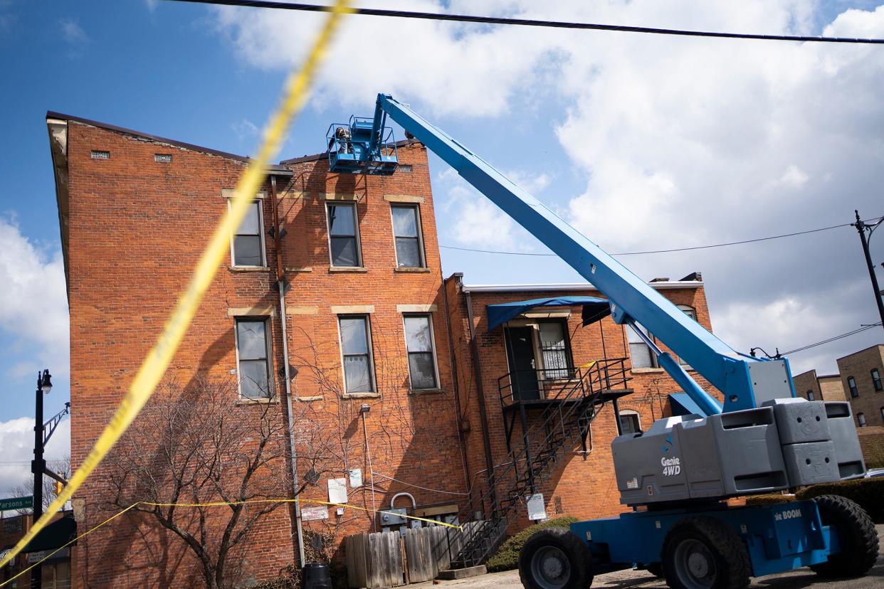 Mar 27, 2023; Columbus, Ohio, USA; Masonries remove loose bricks after high winds brought down the building's chimney and separated part of the roof from the combination commercial and residential building on the corner of Oak Street and Parsons Avenue. The building has been temporarily evacuated as a precaution.