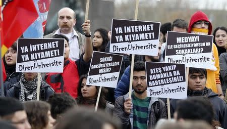 Protesters hold signs and wave flags as they demonstrate against new controls on the Internet approved by the Turkish parliament in Ankara February 22, 2014. The signs read, ''Internet of Doomsday!", "It is impossible to sensor the streets!" and "You can have your own media but you can't get the streets''. REUTERS/Umit Bektas