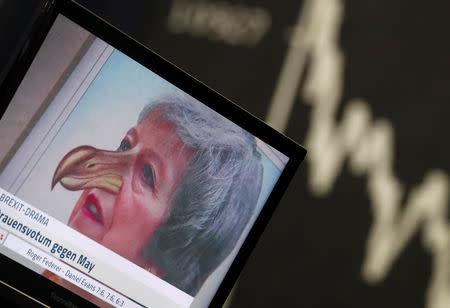 A TV screen is seen next to the German share prize index DAX board the day after the Brexit deal vote of the British parliament during trading at the stock exchange in Frankfurt, Germany, January 16, 2019. REUTERS/Kai Pfaffenbach