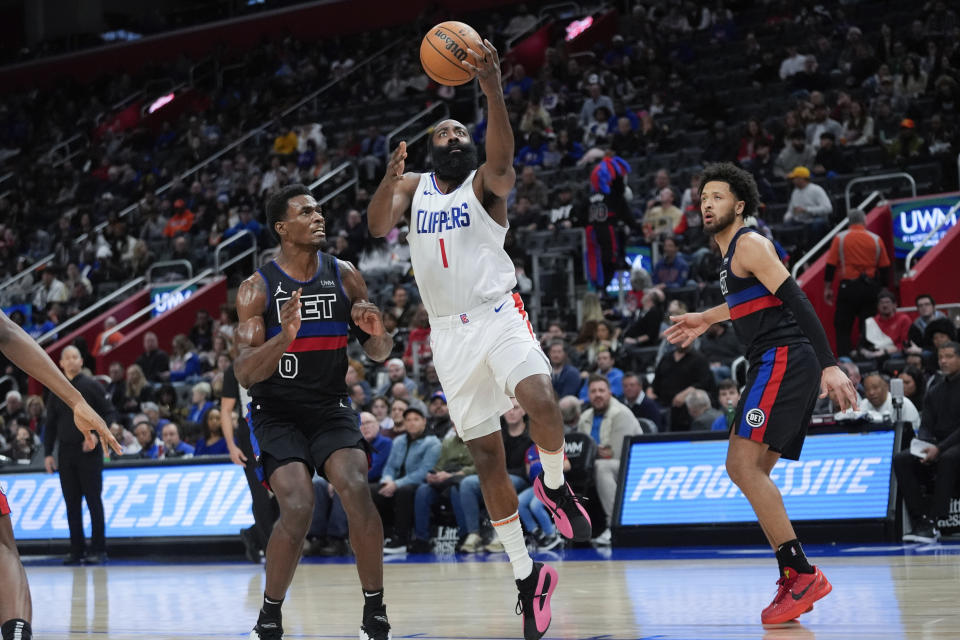 Los Angeles Clippers guard James Harden (1) drives between Detroit Pistons center Jalen Duren (0) and Cade Cunningham (2) in the second half of an NBA basketball game in Detroit, Friday, Feb. 2, 2024. (AP Photo/Paul Sancya)