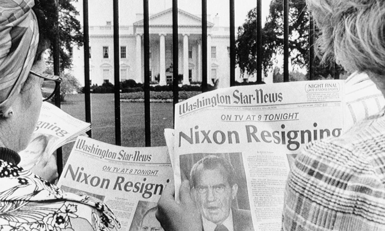 <span>Newspaper headlines read by tourists in front of the White House tell of history in the making.</span><span>Photograph: Bettmann/Bettmann Archive</span>