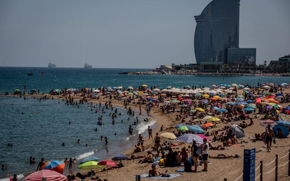 Beachgoers swarm to relax on the sand at Barceloneta beach in Barcelona, - Angel Garcia/Bloomberg