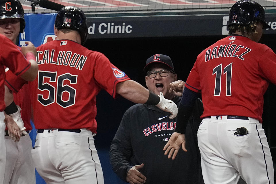 Cleveland Guardians manager Terry Francona, center, greets Jose Ramirez (11) and Kole Calhoun (56) in the dugout after Calhoun hit a three-run home run against the Los Angeles Dodgers during the seventh inning of a baseball game Tuesday, Aug. 22, 2023, in Cleveland. (AP Photo/Sue Ogrocki)