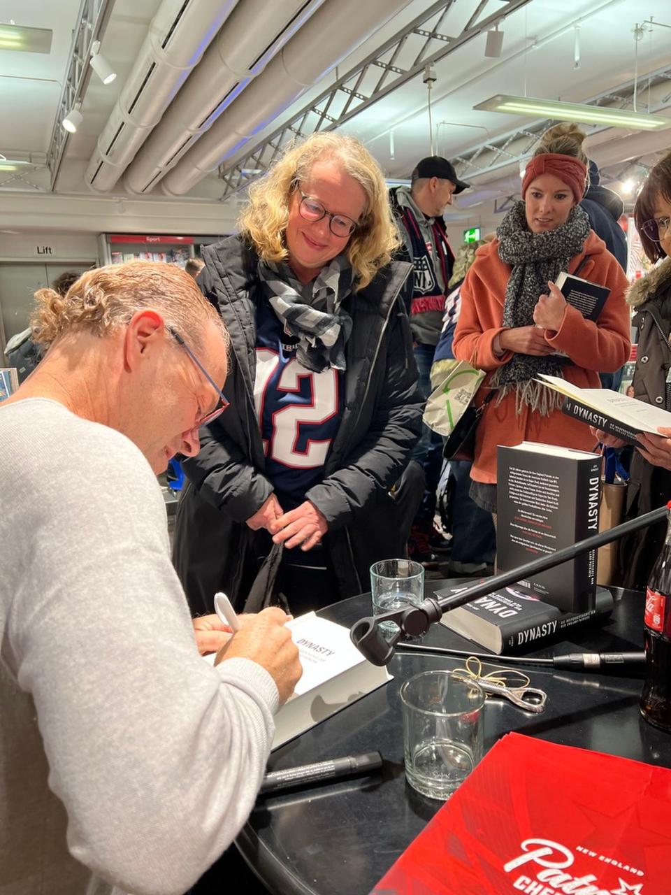 Jeff Benedict, author of the book “The Dynasty,” a look at the New England Patriots, signs a copy of his book in Frankfurt, Germany, in this undated photo. | Jeff Benedict