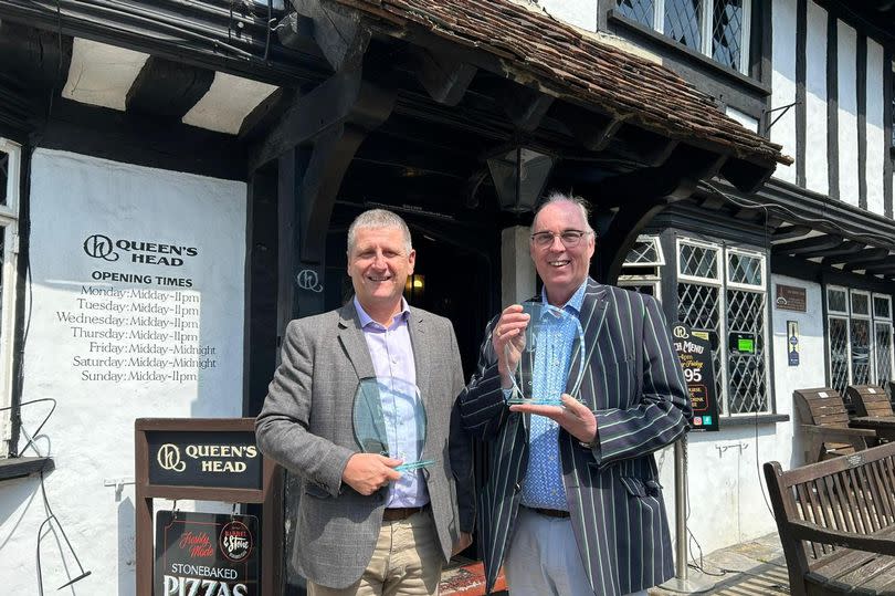 Phil-Arnold (left) presents Sean White, licensee of The Queens Head (Right), with the two awards for the Pinner pub from the pub industry’s nationally recognised Night of Excellence Awards