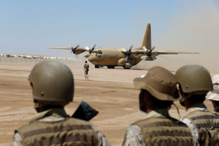 Saudi soldiers watch as a Saudi military cargo plane lands to deliver aid at an airfield in Marib, Yemen January 26, 2018. Picture taken January 26, 2018. Picture taken January 26, 2018. REUTERS/Faisal Al Nasser
