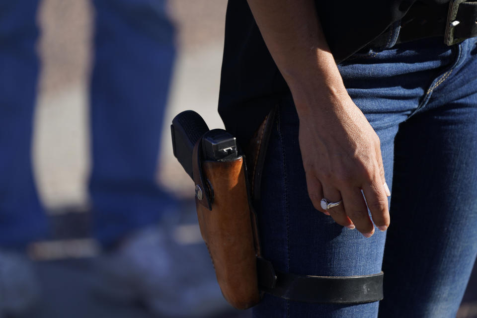 FILE - In this Sept. 4, 2020, file photo, Lauren Boebert, then-Republican candidate for the U.S. House of Representatives seat in Colorado's vast 3rd Congressional District, carries a gun during a freedom cruise staged by her supporters in Pueblo West, Colo. The district's newest representative, Boebert, is an unabashed, social media-savvy loyalist of former President Donald Trump who, like her fellow first-term colleague GOP Rep. Marjorie Taylor Greene of Georgia, is stoking controversy with her far-right views and defiant actions. But unlike Greene, Boebert doesn't hail from an overwhelmingly GOP, safe district. (AP Photo/David Zalubowski, File)