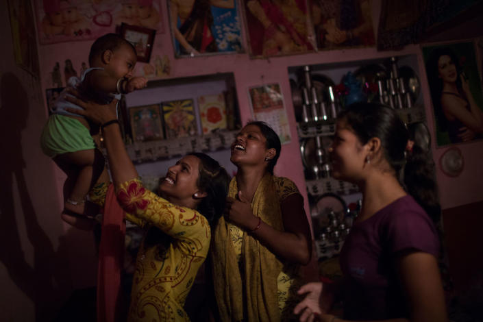 Arti and her sisters play with her son at Arti’s family home in Changedi, Udaipur, Rajasthan, India in July 2016. Her sister, on the right (15) got married some years ago, but started spending time with her family-in-law and her husband around seven months ago. The other sister remains unwed for now. (Photo: Rafael Fabrés)