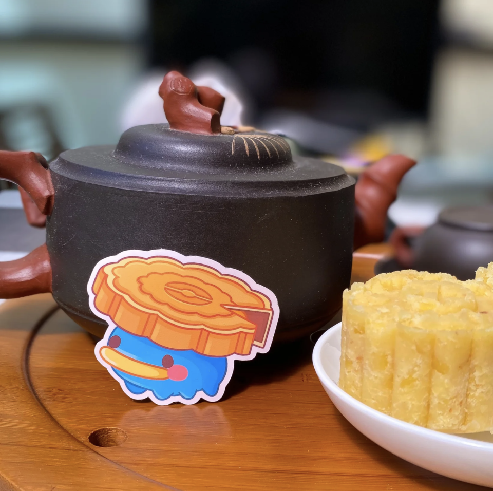 Lotad with mooncake topper sticker next to teapot.