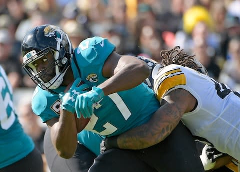 Jacksonville Jaguars running back Leonard Fournette, left, runs for yardage as he is stopped by Pittsburgh Steelers outside linebacker Bud Dupree, right, during the first half of an NFL football game in Jacksonville, Fla. Jaguars coach Doug Marrone says Fournette was responding to racial slurs while yelling at a fan in Nashville - Credit: AP Photo/Phelan M. Ebenhack