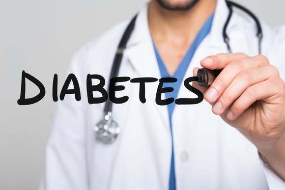 A doctor uses a marker to write the word diabetes in the air in front of him.