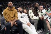 Boston Celtics starters, from left, Al Horford, Derrick White and Jaylen Brown sit on the bench with Payton Pritchard, right, during the first half of an NBA basketball game against the Charlotte Hornets, Friday, April 12, 2024, in Boston. (AP Photo/Michael Dwyer)