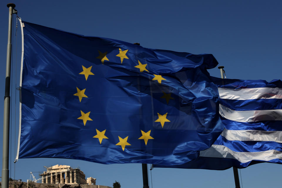 An EU and a Greek flag fly in front of ancient Parthenon temple, in Athens, Sunday, June 17, 2012 as Greeks vote in the most crucial elections in decades. Greece voted Sunday amid global fears that victory by parties that have vowed to cancel the country's international bailout agreements and accompanying austerity measures could undermine the European Union's joint currency and pitch the world's major economies into another sharp downturn. (AP Photo/Petros Giannakouris)